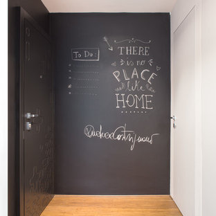 ミラノのシャビーシック調のおしゃれな玄関ロビー (グレーの壁、無垢フローリング、黒いドア) の写真