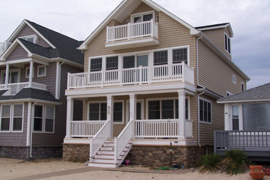 Large elegant beige three-story wood exterior home photo in Other with a shingle roof