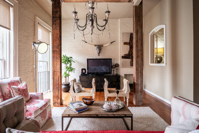Small eclectic loft-style medium tone wood floor and brown floor living room photo in New Orleans with red walls, a corner fireplace, a brick fireplace and a tv stand