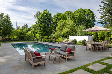 Design ideas for a large contemporary backyard garden in Boston with natural stone pavers.