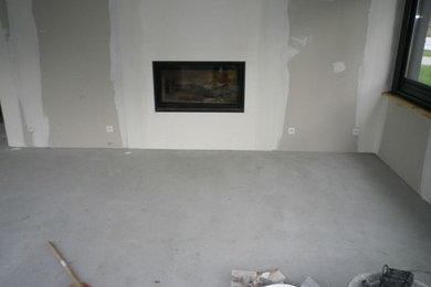 Ejemplo de galería tradicional con suelo de cemento, todas las chimeneas y suelo gris