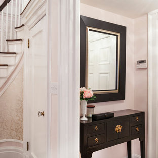 Diseño de distribuidor romántico, grande, con paredes rosas, suelo de madera oscura y puerta simple