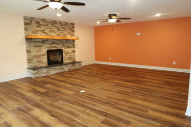 Cette image montre un grand salon minimaliste fermé avec une salle de musique, un mur multicolore, un sol en bois brun, une cheminée standard, un manteau de cheminée en brique et un sol marron.