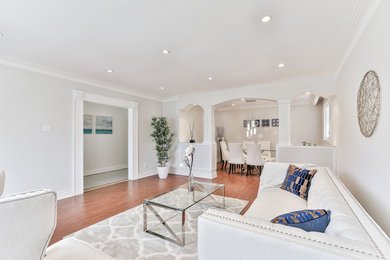 Mid-sized minimalist formal and enclosed plywood floor and brown floor living room photo in Toronto with beige walls and no fireplace