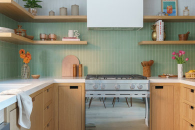 Example of a small trendy u-shaped medium tone wood floor and brown floor enclosed kitchen design in Los Angeles with an undermount sink, flat-panel cabinets, medium tone wood cabinets, quartz countertops, green backsplash, stainless steel appliances, no island and white countertops