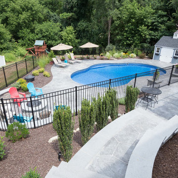 irregular shaped swimming pool with stamped concrete patio