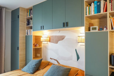 Exemple d'une chambre parentale tendance de taille moyenne avec un mur blanc, parquet clair et du papier peint.