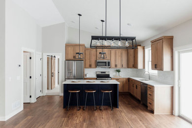 Inspiration for a mid-sized country l-shaped vinyl floor eat-in kitchen remodel in Minneapolis with an undermount sink, shaker cabinets, medium tone wood cabinets, quartzite countertops, white backsplash, porcelain backsplash, stainless steel appliances, an island and white countertops