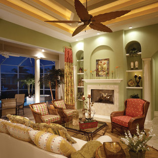 Großes, Fernseherloses, Offenes Mediterranes Wohnzimmer mit grüner Wandfarbe, Kamin und Kaminsims aus Stein in Miami