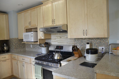 Example of a classic kitchen design in Indianapolis with shaker cabinets, light wood cabinets, laminate countertops, multicolored backsplash, mosaic tile backsplash and stainless steel appliances