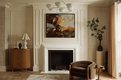Inspiration for a medium sized classic formal enclosed living room curtain in London with medium hardwood flooring, a standard fireplace, a stone fireplace surround, beige floors and panelled walls.