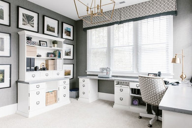 Photo of a large transitional craft room in Charlotte with grey walls, carpet, a built-in desk and beige floor.