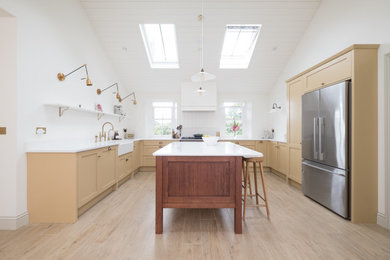 Design ideas for a medium sized traditional u-shaped open plan kitchen in Other with a belfast sink, shaker cabinets, yellow cabinets, quartz worktops, white splashback, tonge and groove splashback, stainless steel appliances, porcelain flooring, an island, white worktops, a timber clad ceiling and feature lighting.