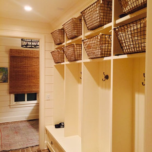 Inspiration för mellanstora eklektiska kapprum, med beige väggar, tegelgolv och rött golv