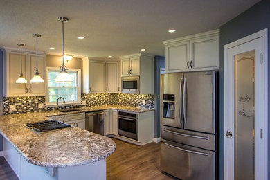 Eat-in kitchen - large contemporary u-shaped medium tone wood floor and brown floor eat-in kitchen idea in Other with a drop-in sink, beaded inset cabinets, beige cabinets, granite countertops, multicolored backsplash, ceramic backsplash, stainless steel appliances and a peninsula