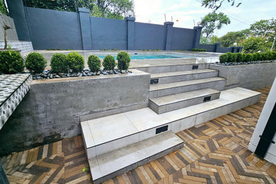 Mid-sized urban side yard tile and rectangular aboveground pool landscaping photo in Other