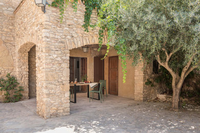 Ejemplo de patio de estilo de casa de campo de tamaño medio en patio delantero y anexo de casas con adoquines de piedra natural