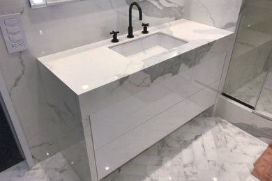 Example of a mid-sized minimalist white tile and marble tile single-sink bathroom design in New York with white cabinets, marble countertops, white countertops and a floating vanity