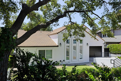 Inspiration for a large modern white one-story stucco exterior home remodel in Los Angeles with a tile roof and a red roof