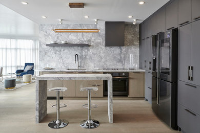 Mid-sized contemporary l-shaped open plan kitchen in Toronto with an undermount sink, flat-panel cabinets, grey cabinets, quartzite benchtops, grey splashback, stone slab splashback, black appliances, with island, grey benchtop, light hardwood floors and brown floor.