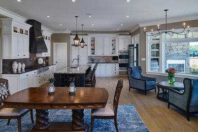 Inspiration for a mid-sized transitional single-wall light wood floor eat-in kitchen remodel in Philadelphia with a drop-in sink, recessed-panel cabinets, light wood cabinets, granite countertops, metallic backsplash, ceramic backsplash, stainless steel appliances and an island