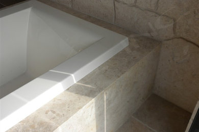 Bathroom - tropical stone slab travertine floor and beige floor bathroom idea in Hawaii with medium tone wood cabinets, an undermount tub, beige walls, an undermount sink and beige countertops