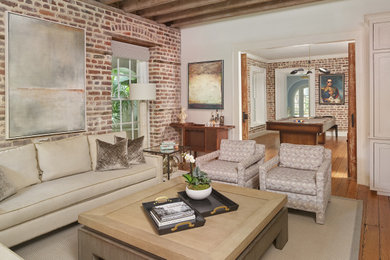 Inspiration for a large transitional open concept medium tone wood floor, brown floor, exposed beam and brick wall family room remodel in Charleston