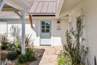 Coastal white two-story stucco exterior home idea in Other with a shingle roof and a brown roof