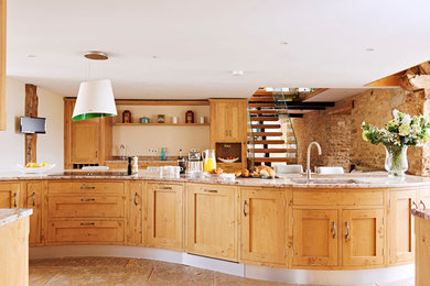 Country kitchen in Gloucestershire with an undermount sink, shaker cabinets, medium wood cabinets and with island.