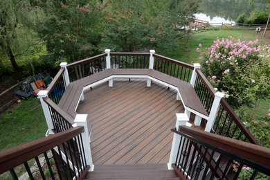 Example of a large trendy backyard deck design in DC Metro with no cover