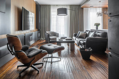 На фото: парадная, открытая гостиная комната в современном стиле с коричневыми стенами, паркетным полом среднего тона, телевизором на стене и коричневым полом с