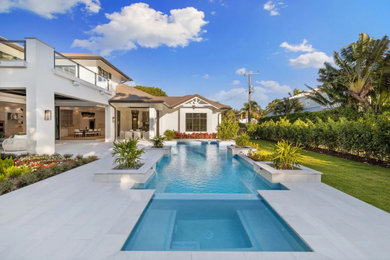 Example of a mid-sized minimalist backyard stone and rectangular lap hot tub design in Miami