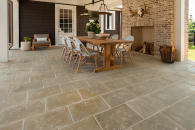 Example of a mid-sized cottage backyard concrete paver patio design in Houston with a fire pit and a roof extension