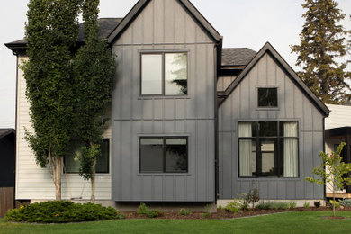 Large scandinavian gray two-story concrete fiberboard and board and batten house exterior idea in Calgary with a mixed material roof and a black roof