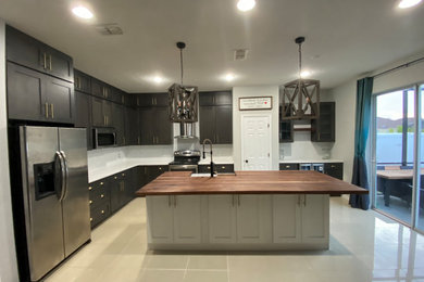 オーランドにある高級な広いカントリー風のおしゃれなキッチン (エプロンフロントシンク、シェーカースタイル扉のキャビネット、グレーのキャビネット、木材カウンター、白いキッチンパネル、セラミックタイルのキッチンパネル、シルバーの調理設備、磁器タイルの床、ベージュの床、白いキッチンカウンター) の写真
