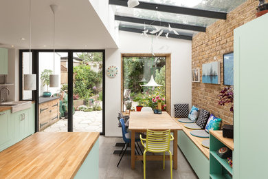 This is an example of a mid-sized eclectic kitchen/dining combo in London with concrete floors and grey floor.