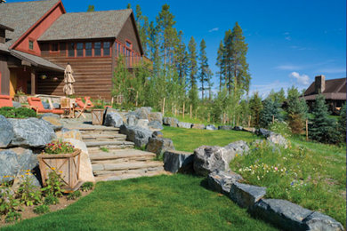 Photo of a mid-sized rustic full sun backyard stone landscaping in Denver for summer.