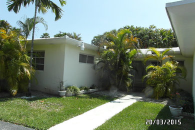 Example of a mid-sized beach style one-story stucco exterior home design in Miami