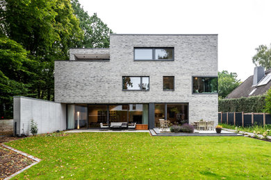 Großes, Dreistöckiges Modernes Einfamilienhaus mit Steinfassade und Flachdach in Hamburg