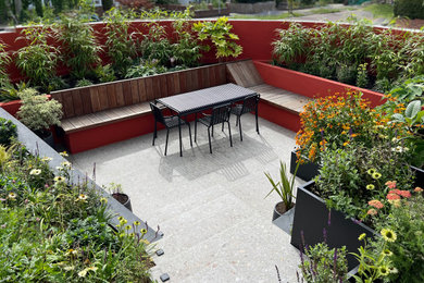 This is an example of a small contemporary courtyard patio steps in London with tiled flooring and no cover.