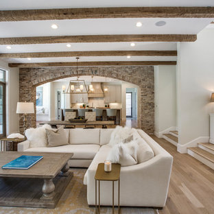 Imagen de salón abierto, mediterráneo, con paredes verdes, suelo de madera en tonos medios y suelo marrón