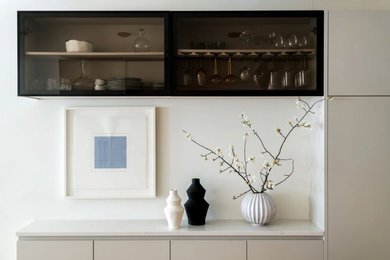 Example of a single-wall dry bar design in Philadelphia with glass-front cabinets, black cabinets, marble countertops and white countertops