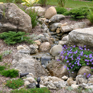 Design ideas for a large traditional backyard full sun garden for spring in Toronto with concrete pavers and with waterfall.
