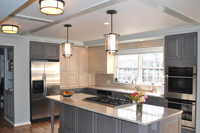 Elegant l-shaped medium tone wood floor and brown floor kitchen photo in DC Metro with an undermount sink, raised-panel cabinets, gray cabinets, beige backsplash, ceramic backsplash, stainless steel appliances, an island, beige countertops and granite countertops