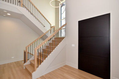 Example of a minimalist wooden u-shaped wood railing staircase design in Chicago with wooden risers