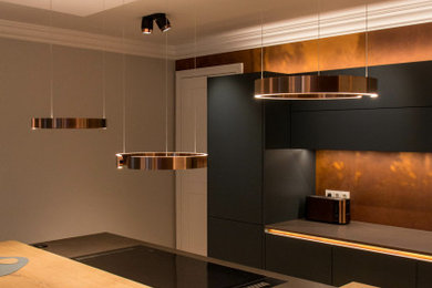 Offene, Geräumige Moderne grifflose Küche mit schwarzen Schränken, Küchenrückwand in Braun, dunklem Holzboden, Kücheninsel und Tapetendecke in Hamburg