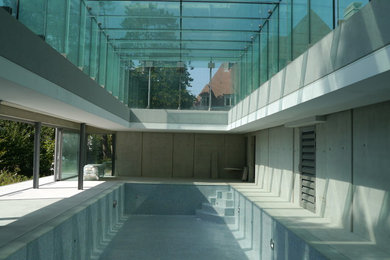 Aménagement d'une grande piscine latérale contemporaine rectangle avec des pavés en pierre naturelle.