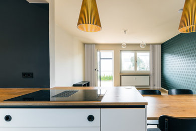 Mittelgroßes, Fernseherloses, Offenes Modernes Wohnzimmer mit beiger Wandfarbe, braunem Holzboden, braunem Boden und Tapetenwänden in München