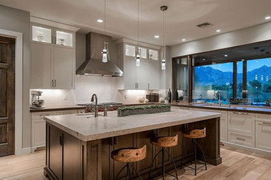 Design ideas for a mid-sized transitional u-shaped eat-in kitchen in Phoenix with an undermount sink, shaker cabinets, white cabinets, granite benchtops, white splashback, subway tile splashback, stainless steel appliances, light hardwood floors, with island, beige floor and beige benchtop.