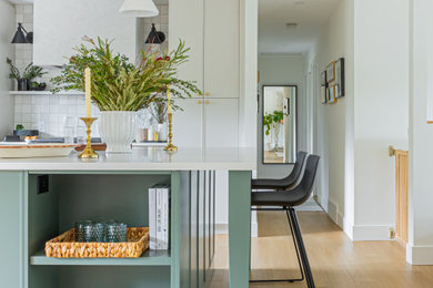 Inspiration for a mid-sized transitional u-shaped vinyl floor and multicolored floor eat-in kitchen remodel in Vancouver with an undermount sink, shaker cabinets, white cabinets, quartzite countertops, white backsplash, cement tile backsplash, stainless steel appliances, an island and multicolored countertops